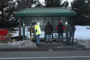 Suffolk County DPW workers clearing snow and ice from bus shelter on Route 58 yesterday. (RiverheadLOCAL photo by Peter Blasl)