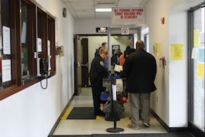 People wait in line to be scanned in the hallway outside the entrance to Riverhead Justice Court Monday. (RiverheadLOCAL photo by Denise Civiletti)