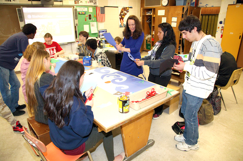 Joyce Raimondo works with members of the art club on the design of a mural.