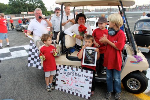 Riverhead Raceway Wall of Famer Peggy Smith with grand-nephews as Bob Finian, left, makes presentation during ceremonies on the track Saturday night. (Photo: Peter Blasl) 