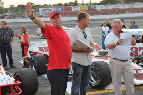 Dan Turbush waves to fans during ceremonies at Riverhead Raceway Saturday night, where he was inducted into the "Wall of Fame." Pictured also are track manager John Ellwood and host Bob Finian. (Photo: Peter Blasl) 