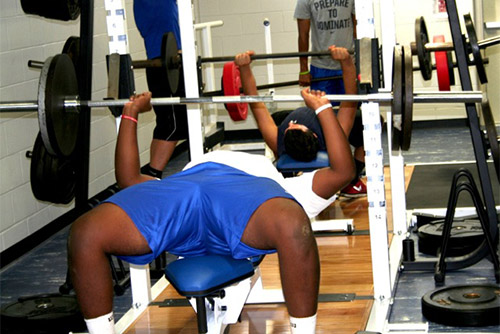 Ethan Greenidge, who will head a deep offensive line this year, using the equipment in the new weight room.