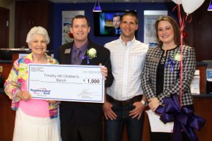 Fern Hill, left, and Monte Gibson, second from right, accept a donation from People's United Riverhead branch managers Matt Carvel and Shannon Murphy. (Photo: Peter Blasl)