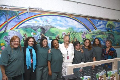Artist Diana Fogarty, second from left, benefactor Theresa Santmann, center, and volunteer Liz Stokes, far right, with inmates at the county jail in Riverside, where a Fogarty's mural, was unveiled in the visiting room this morning. 