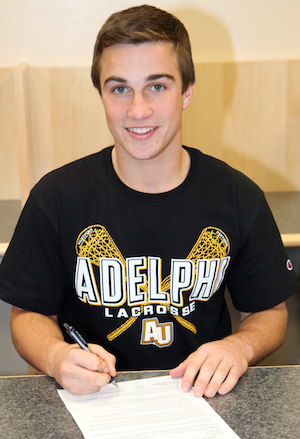 Mark Andrejack signs a letter of intent to play for Adelphi yesterday at Riverhead High School.
