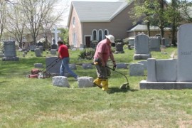 George Lenihan, left, and Robert Lucas mowed and trimmed grass at St. John's Cemetery Sunday morning. Photo: Denise Civiletti