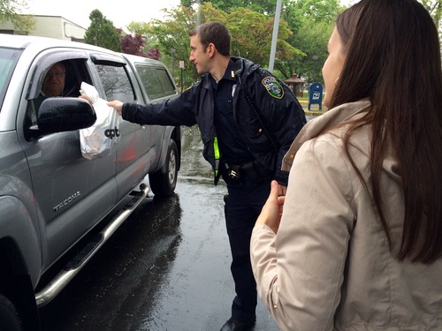 Police Officer Daniel Hogan takes a bag of medications from a resident at the drive-up takeback event yesterday morning. Photo: Denise Civiletti