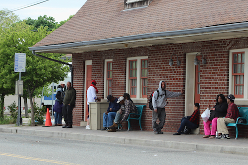Passengers wait at a Suffolk County bus stop in front of the train station on Railroad Avenue. Photo: Katie Blasl