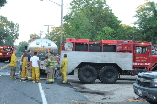 Firefighters refill a brush truck with water from a tanker. Photo: Denise Civiletti