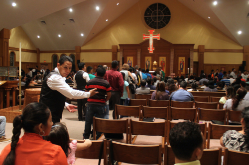 Parishioners receive communion during the Spanish Mass at St. John's, a service that draws hundreds every Sunday evening. Photo: Denise Civiletti