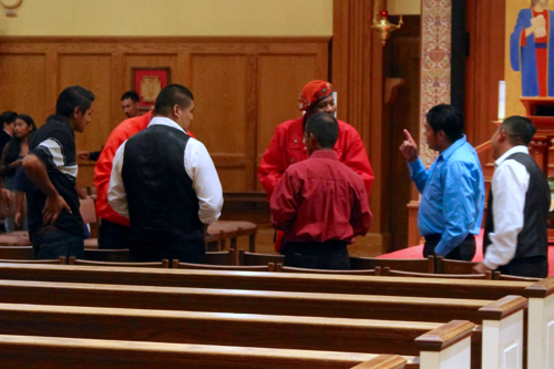 Parishioners speak with members of the Guardian Angels after the Spanish Mass Sunday night at St. John's. Photo: Denise Civiletti