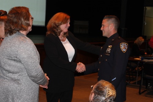 Superintendent Nancy Carney greets the police officer who saved the lives of two district employees last week. Photo: Denise Civiletti