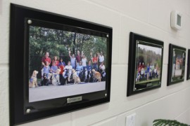 Framed photos of classes that have "graduated" from Canine Companions program hang in the hallway. Photo: Katie Blasl