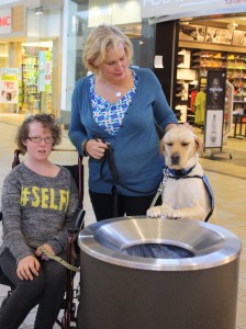Johanna and her mother walk through Smithaven Mall with Rae during one of the program's "field trips," which allow the dogs and their new owners to test the waters in public. Photo: John Bentzinger