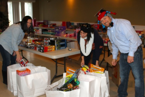 Tom Farruggia, right, and employees at John Wesley Village assemble gifts their office Dec. 18 for a Salvation Army program in Riverhead. Photo: Peter Blasl